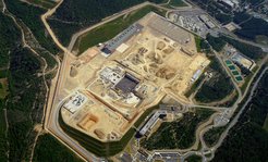 Das ITER-Gelände in Cararache im Juni 2013: In Zentrum die Fundamente der Tokamak-Halle, links oben die Halle, in der die Poloidalfeldspulen hergestellt werden, rechts unten das bereits bezogene Verwaltungsgebäude.