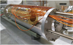 View of the interior of the particle trap for electrons or positrons. The circular phosphor screen at the front right can detect how many particles the trap encloses.